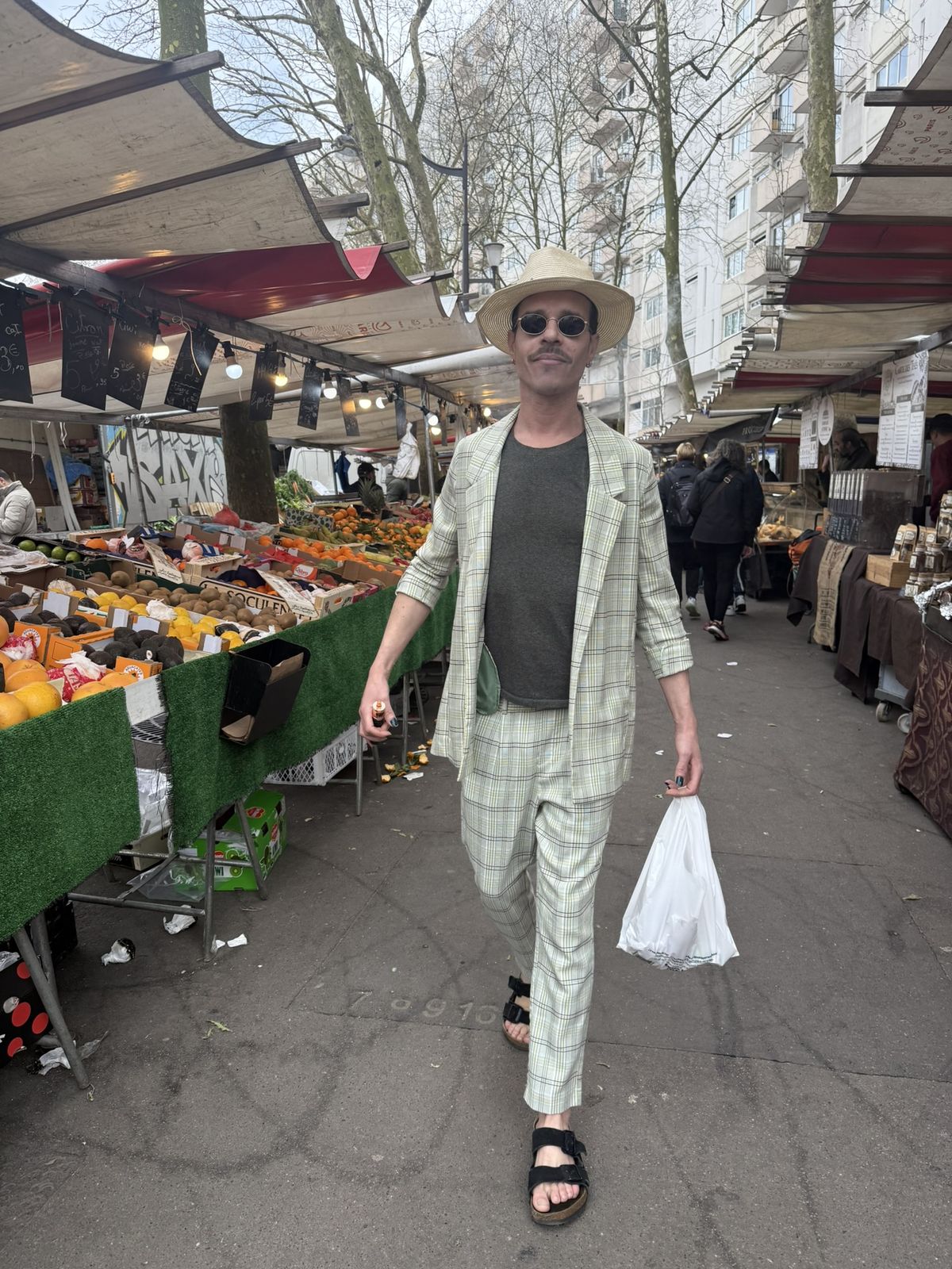 Ben marche dans une allée de marché, costume clair