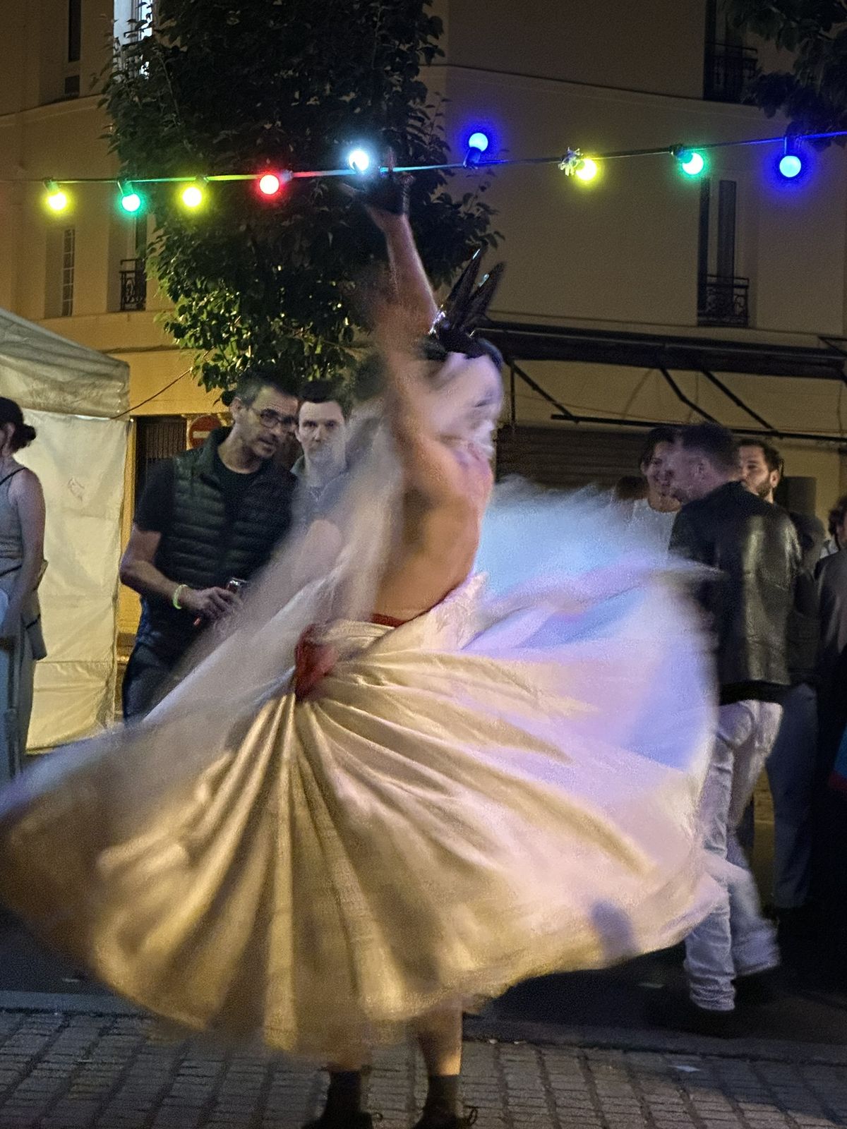 Ben fait tourner sa robe blanche sous des guirlandes lumineuses